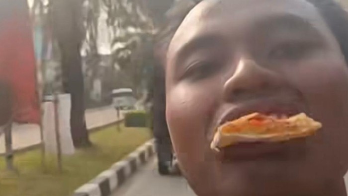 Viral pria Depok makan pizza sambil motoran, nyetir pakai kaki