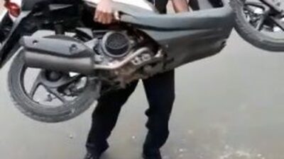 foto seseorang mengangkat motor
